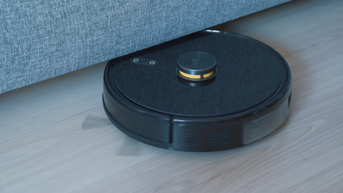 Black round robot vacuum cleaner on a light wooden floor next to a grey sofa
